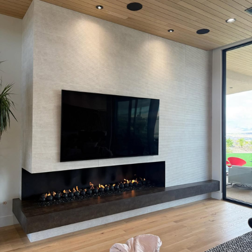 left-corner 8’ custom Mason Lite fireplace featuring sleek black glass and bold cannon ball accents.