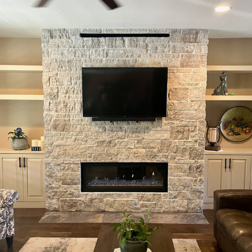 Napoleon Vector 50” linear gas fireplace with silver crushed glass, surrounded by Mountain Ridge stone with Trinity White mortar